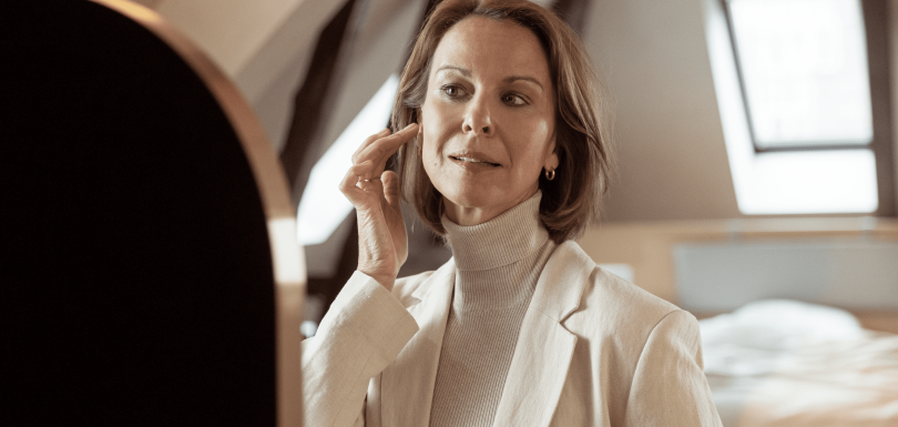 Woman smiling putting in a comfortable hearing aid