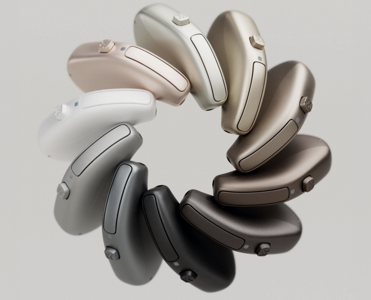 A circular display of modern hearing aids in different colours, available at Kensington Hearing.