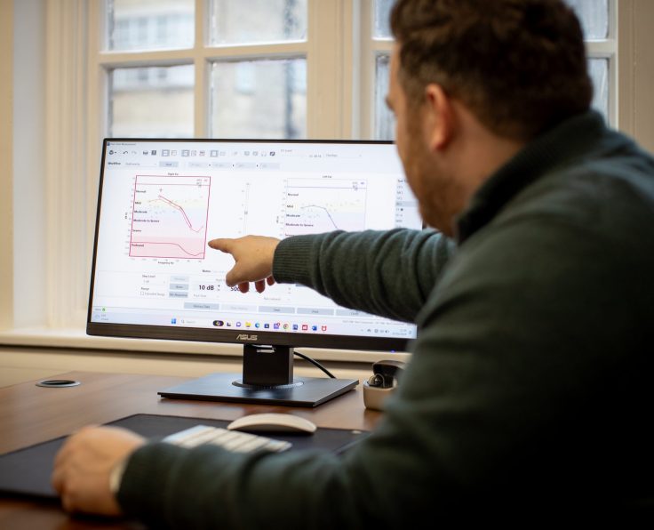 Audiologist explaining a patient’s audiogram results during a consultation at Kensington Hearing London.