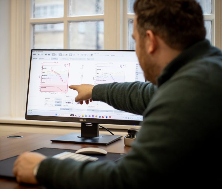 Audiologist explaining a patient’s audiogram results during a consultation at Kensington Hearing London.