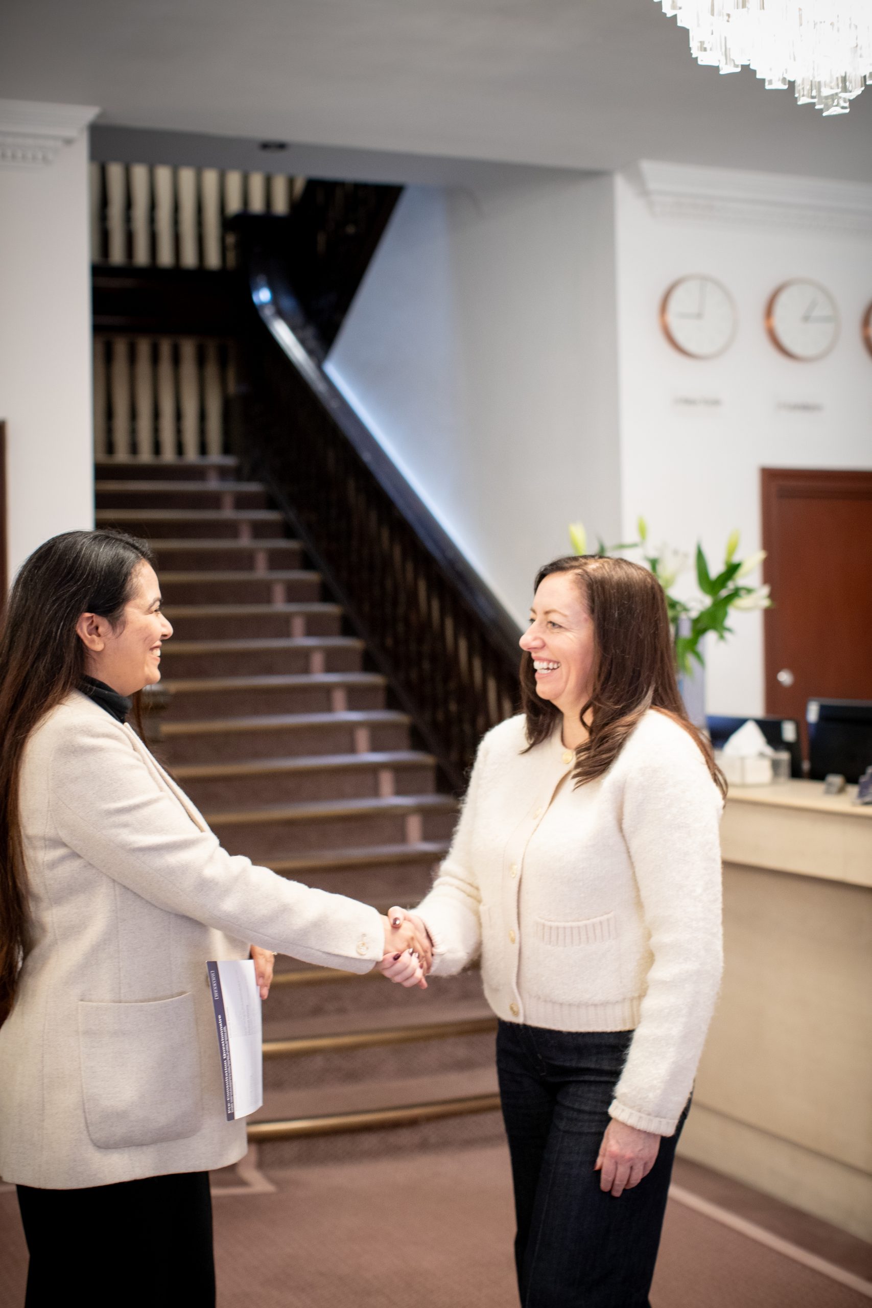 Patient being warmly welcomed at Kensington Hearing clinic in London.
